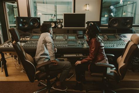 sound producers sitting at recording studio and discussing - Greenwave