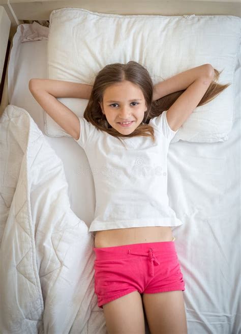 A Girl In Pajamas Lies On The Bed And Writes A Letter To Santa Claus Or