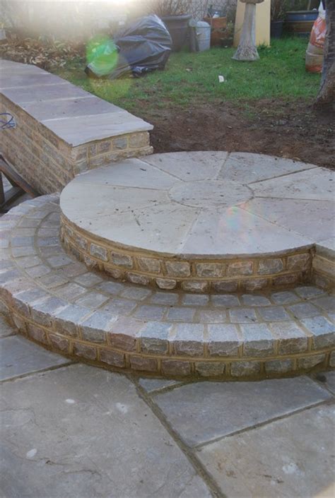 Retaining wall is a structure that are designed and constructed to withstand lateral pressure of soil or hold back soil materials. Circular stone steps and seating wall - Traditional ...