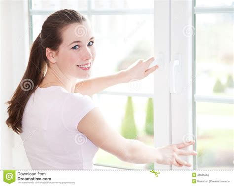 Привлекательная женщина закрывает окно Стоковое Фото изображение насчитывающей провентилируйте