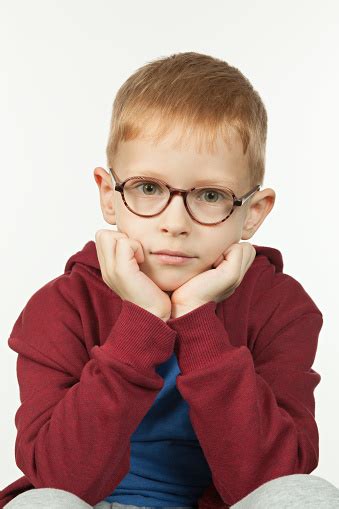 Studio Portrait Of A 7 Year Old Redhaired Boy In Glasses On A White