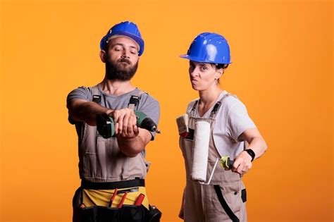 premium photo builders posing with construction or renovation tools on camera preparing to do