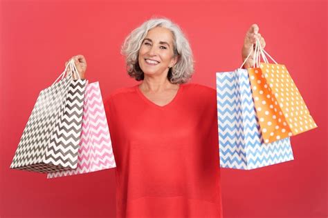 Premium Photo Happy Mature Woman Standing Showing Shopping Bags