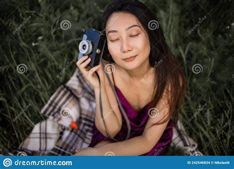 Beautiful Asian Woman With Retro Camera On Grassland In Green Field