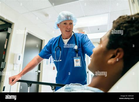 Nurse Talking To Boy In Hospital Bed Stock Photo Alamy