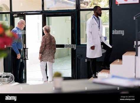Elderly couple leaving hospital waiting room after having medical