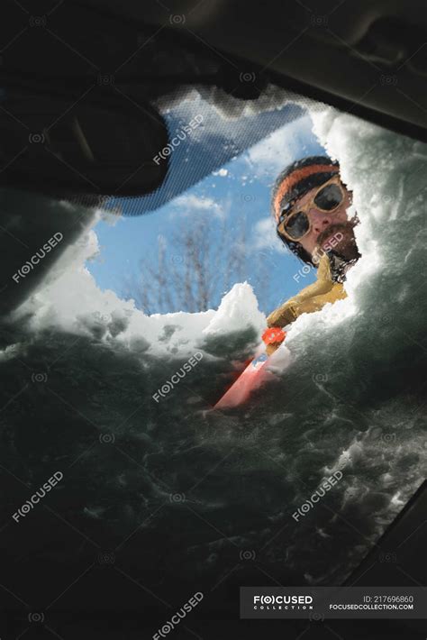 Man Cleaning Snow From Car Windshield During Winter — Clearing