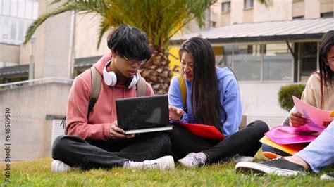 Asian Student Couple Sitting On Grass In High School Playground Two