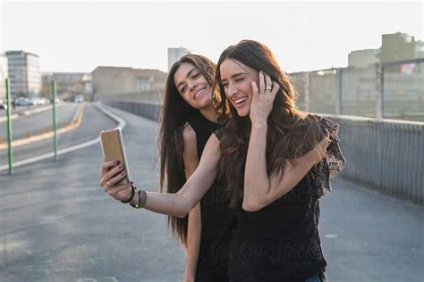 Two Friends Taking A Selfie In The City By Gic For Stocksy United
