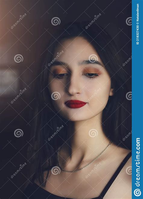 Portrait Of A Beautiful Dark Haired Girl With Red Lipstick On Her Lips