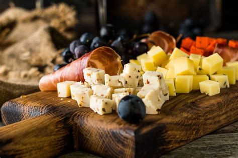 Premium Photo Assorted Cheeses On Wooden Board Plate