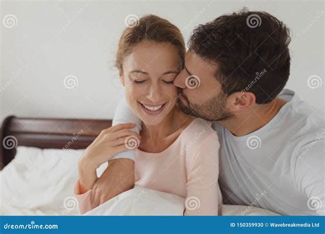 Man Kissing Woman On Bed In Bedroom Stock Photo Image Of Closeness