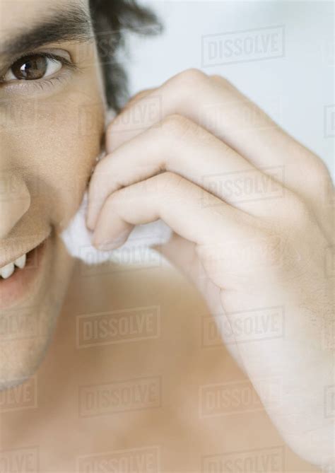 Man Rubbing Cheek With Cotton Ball Stock Photo Dissolve