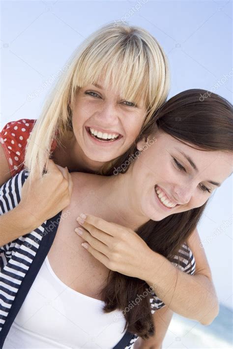 Two Female Friends Embracing On Beach — Stock Photo © Monkeybusiness