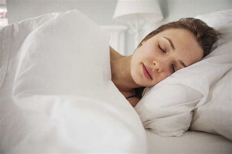 Woman Sleeping On Bed At Home Stock Photo