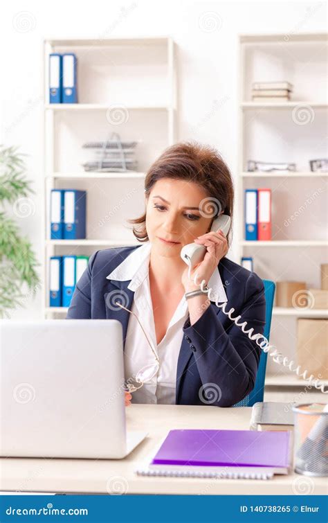 the middle aged female employee sitting at the office stock image image of computer busy