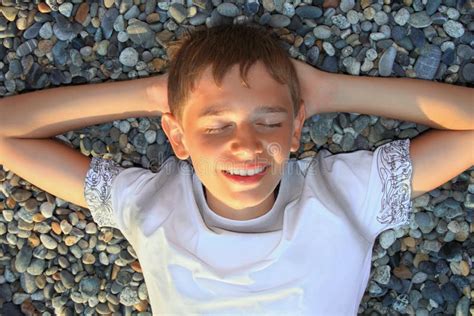 Muchacho Del Adolescente Que Miente En Las Piedras Ojos Cerrados Imagen De Archivo Imagen De