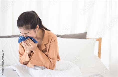 Young Asian Woman Sneezing And Blowing Her Nose With Handkerchief On