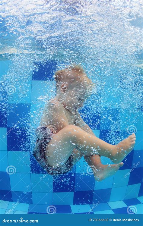 Little Child Swimming With Fun And Diving Down In Pool Stock Photo