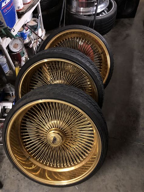 Gold Rims And Tires Are Stacked On Top Of Each Other