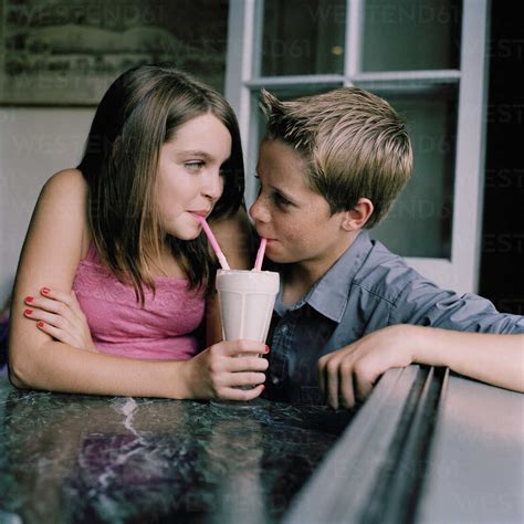 A Young Teenage Couple Sharing A Milkshake At A Diner Stock Photo