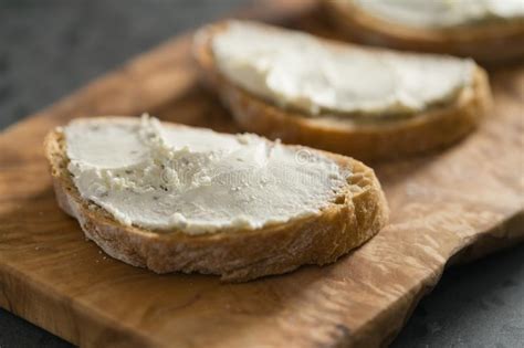 Three Ciabatta Slices With Cream Cheese On Olive Wood Board On Terrazzo Surface Stock Image