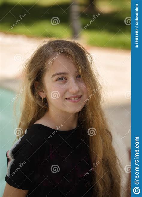 Portrait Of A Smiling Teenager Girl With Long Blonde Hair Stock Photo