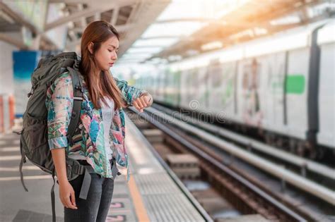 Asian Woman Traveler Tourist Waiting Modern Train And Looking Watch At Train Station Selective