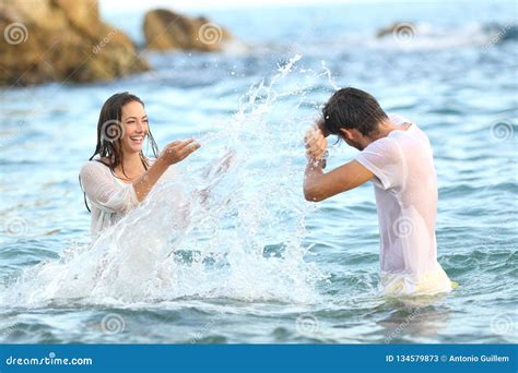 Spontaneous Couple Joking Throwing Water On The Beach Stock Image Image Of Happy Beautiful