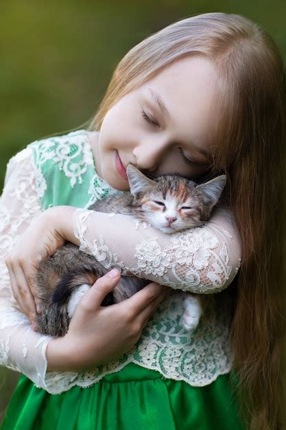 Little Girl Holding A Kitten Premium Photo