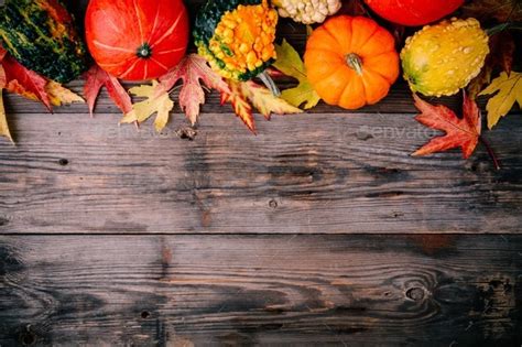 Colorful Pumpkins And Fall Leaves On Wooden Background