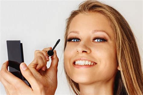 Beautiful Woman Holds Brush Of Mascara And Puts On Cosmetics On Her