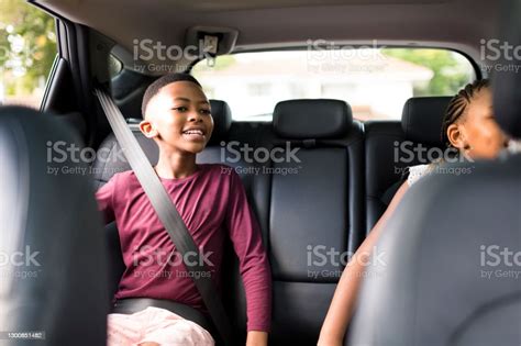 Happy Boy And Sister In Backseat Of Car Seatbelts On Stock Photo