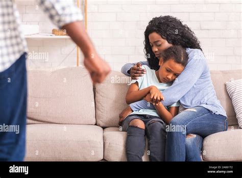 Afro mother and daughter suffering from domestic violence of father