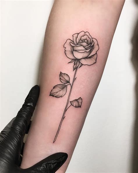 A Black And White Rose Tattoo On The Arm