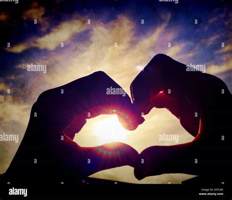 Childs Hands Forming Heart Shape Against Sun Stock Photo Alamy