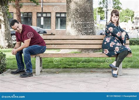 Arguing Mixed Race Couple Sitting Facing Away From Each Other On Park
