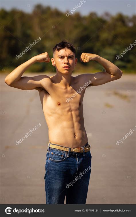 Eighteen Year Old Teenage Boy Flexing His Arm Muscles Warm Stock Photo