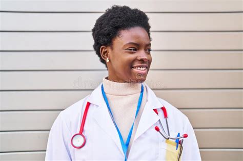 African American Woman Wearing Doctor Uniform Standing At Street Stock