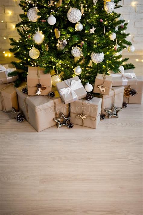 decorated christmas tree and heap of t boxes copy space over wooden floor background stock