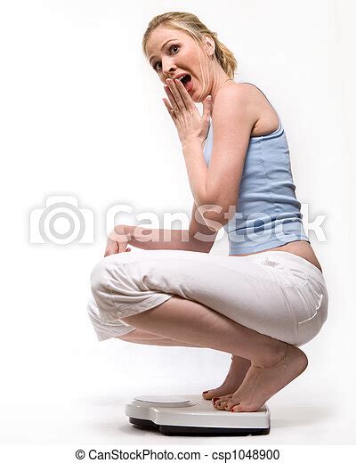 Weight Loss Attractive Blond Woman Squatting Down On A Bathroom Scale