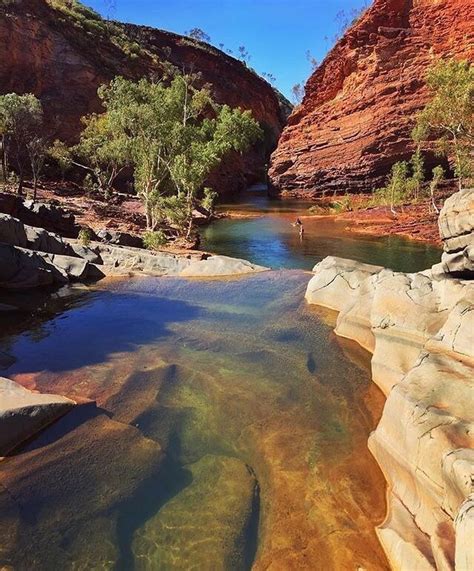 A River Running Through A Canyon Surrounded By Red Rocks