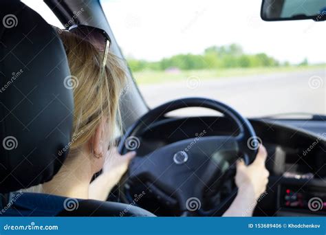 Young Woman Driving Car On A Highway View From The Back Stock Photo