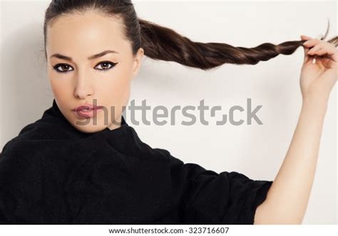 Beautiful Brunette Holds Her Long Ponytail Stock Photo