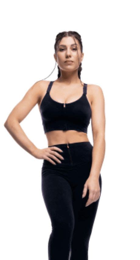 A Woman In Black Sports Bra Top And Leggings With Her Hands On Her Hips