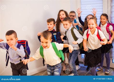 Happy School Kids Running In Elementary School Hallway Front View