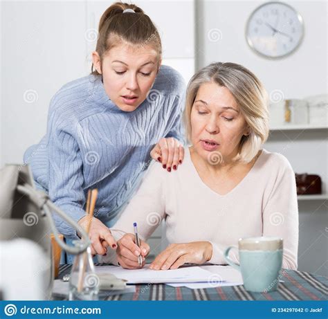 Woman And Adult Daughter Fill Out Paperwork Stock Photo Image Of