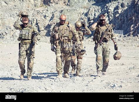 Team Squad Of Special Forces In Action In The Desert Among The Rocks