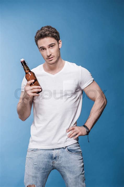 Handsome Young Man Holding Beer Bottle And Looking At Camera Stock