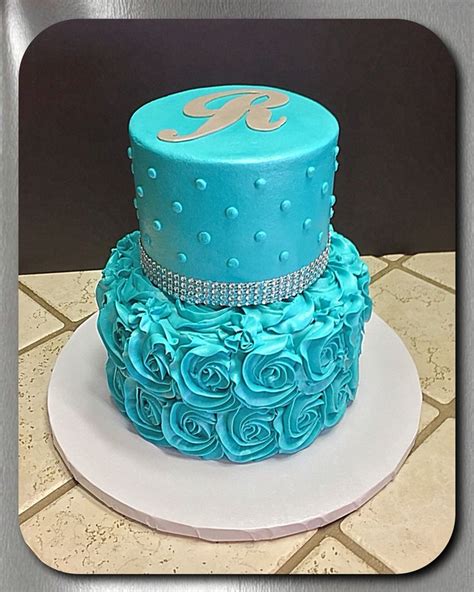 Two Tiered Cake With Blue Frosting And Rosettes